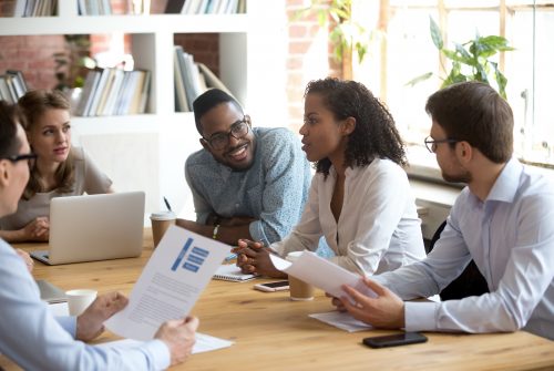 African young project manager speaking at diverse meeting sharing creative ideas telling opinion at group briefing, black female employee talking reporting about corporate work result, team listening